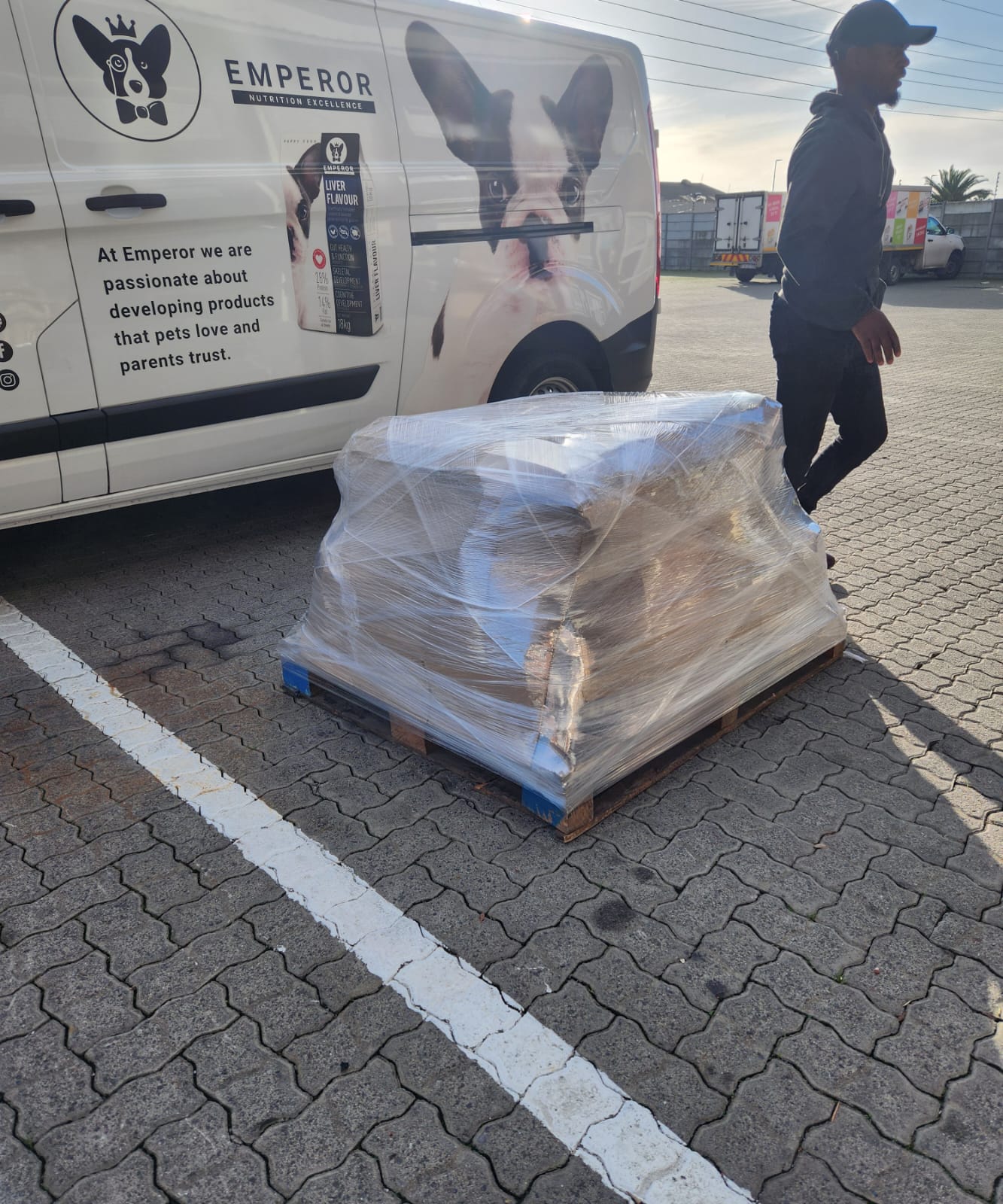 A wrapped product pallet beside an Emperor-branded delivery van